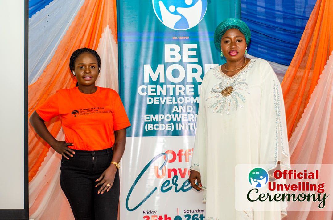 Team member with a guest of honour beside the banner