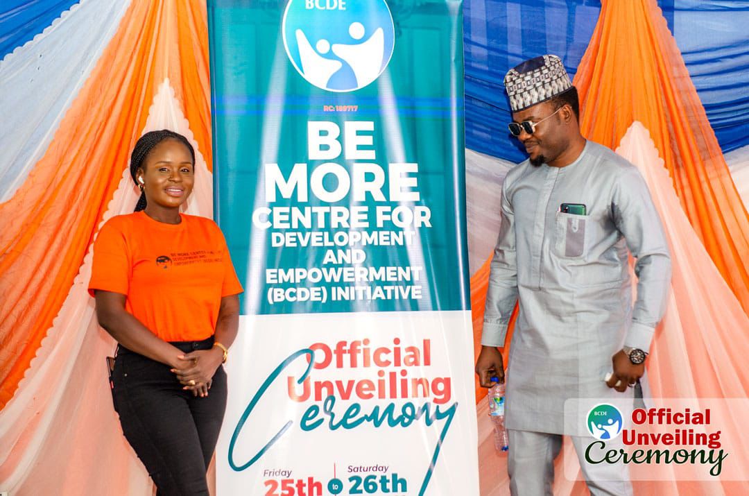 Staff member and a guest posing beside the banner