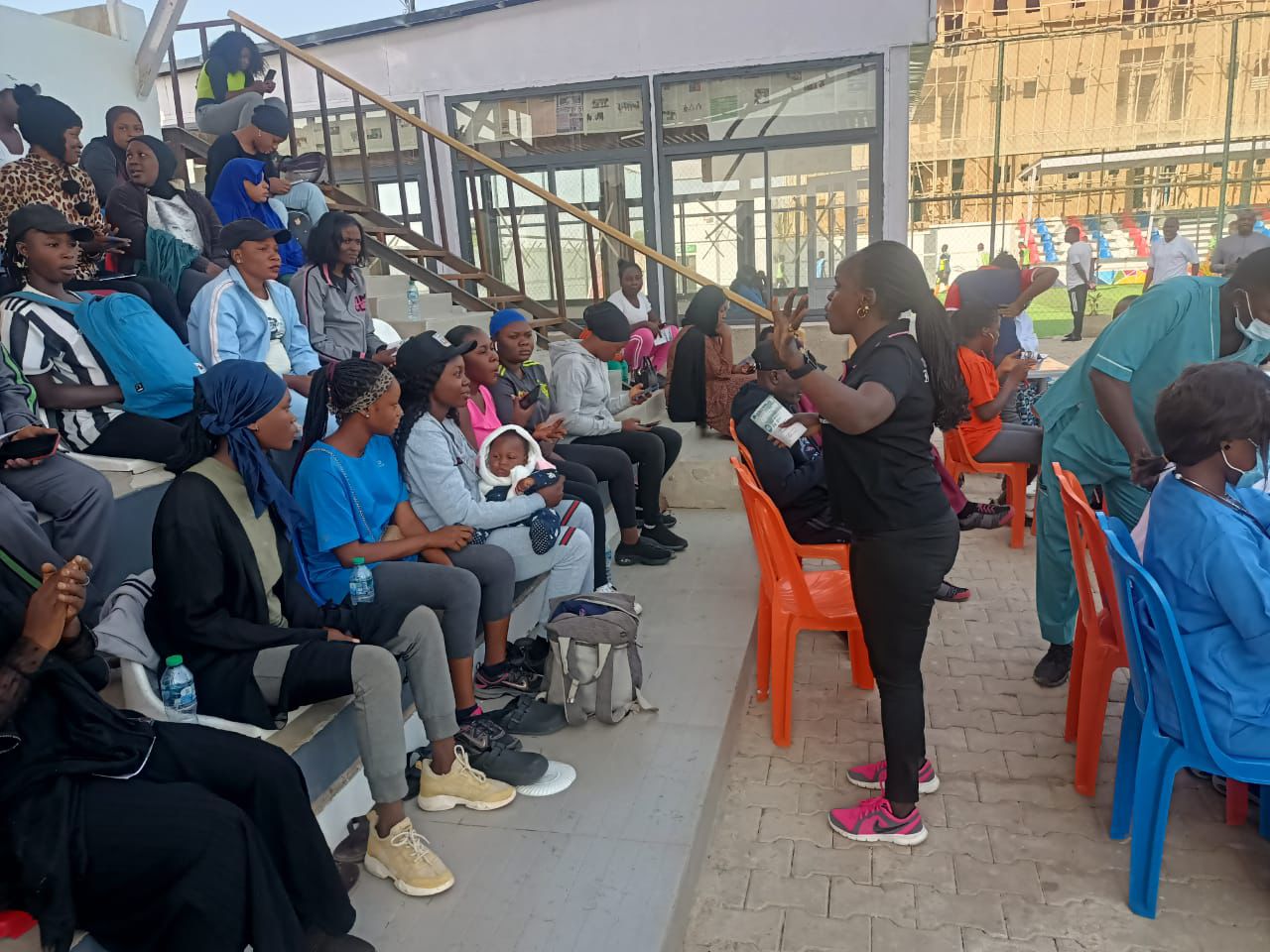 Facilitator addressing seated community members at an event