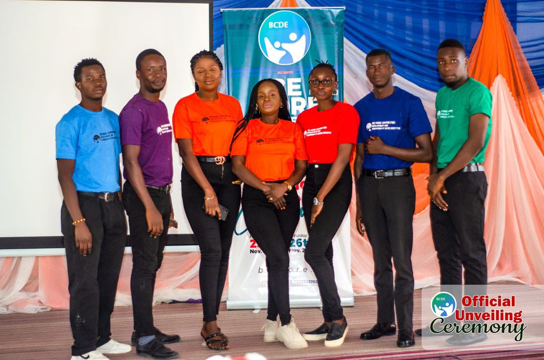 Group of young volunteers posing together on stage